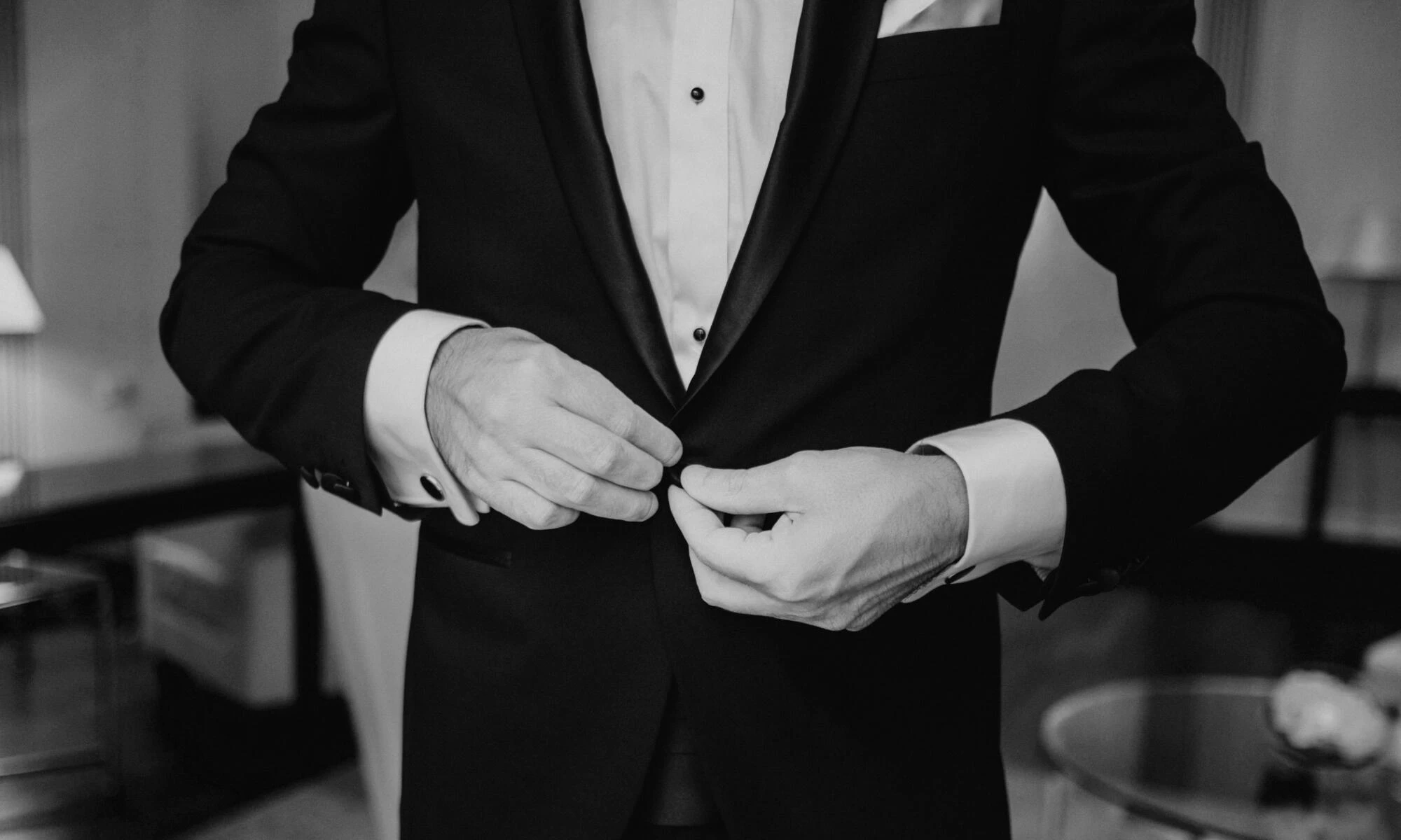 A man adjusts the jacket of his suit